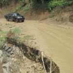 Mobil melintasi ruas Jalan Km 16 Bireuen yang amblas akibat hujan deras yang melanda Bireuen. Foto IST