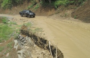 Mobil melintasi ruas Jalan Km 16 Bireuen yang amblas akibat hujan deras yang melanda Bireuen. Foto IST