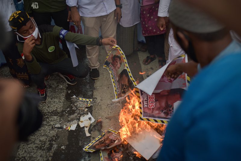 Massa Aliansi Ormas Islam Aceh membakar foto residen Prancis, Emmanuel Macron, dalam aksi Bela Nabi Muhammad SAW, Selasa (3/11/2020) di depan Masjid Raya Baiturrahman Banda Aceh. (Foto Riska Munawarah)