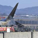 Petugas dan anggota tim penyelamat bekerja di landasan pacu Bandara Internasional Muan di Muan, Korea Selatan, Minggu, 29 Desember 2024. Foto: AP/Lee Young-ju