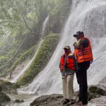 Pj Gubernur Aceh Safrizal dan istrinya Safriati mengarungi Krueng Teunom untuk menikmati air terjun Ceuraceu Eumbon, di Gampong Alue Jang, Kecamatan Pasie Raya, Kabupaten Aceh Jaya, pada Minggu (19/1/2025). Foto: Biro Adpim