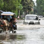 Pengendara mobildan delman melintasi genangan air di Jalan Boulevard Barat Raya, Kelapa Gading, Jakarta Utara, Rabu (29/1/2025). (Foto: ANTARA FOTO/Fakhri Hermansyah/YU)